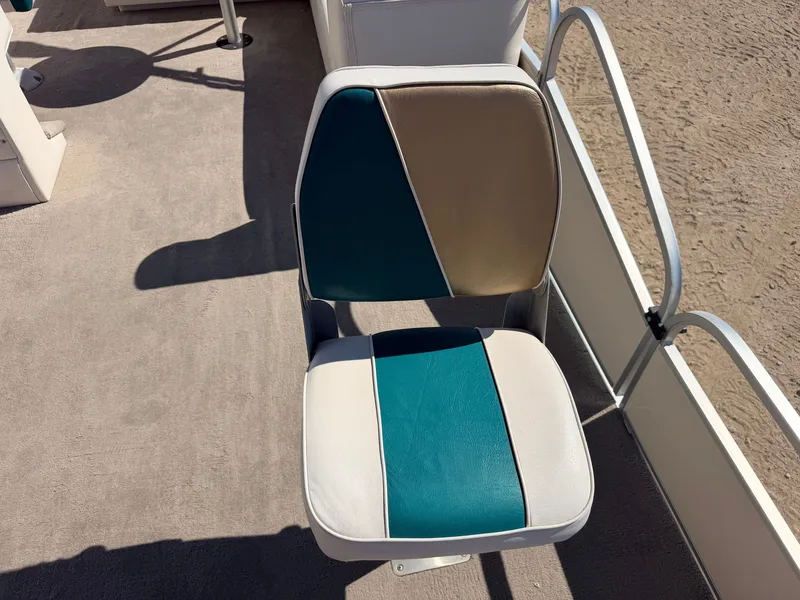 Slide: The Image of A boat seat with blue, beige, and white upholstery on a deck. - 12