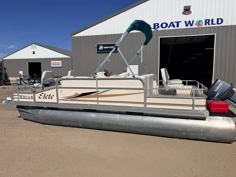 Slide: The Image of A 2006 Elete pontoon boat with a 50HP Yamaha engine is parked outside a boat dealership. - 45