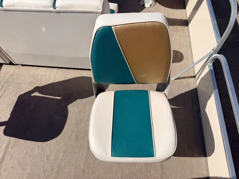 Slide: The Image of A boat seat with blue, gold, and white upholstery on a deck. - 37