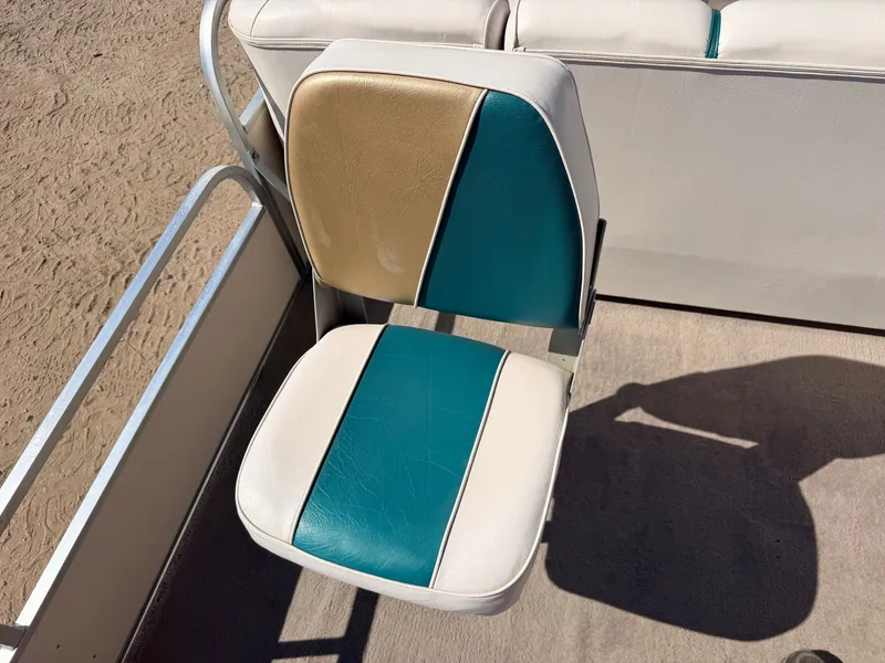 Slide: The Image of A boat seat with blue, gold, and white upholstery on a deck. - 35