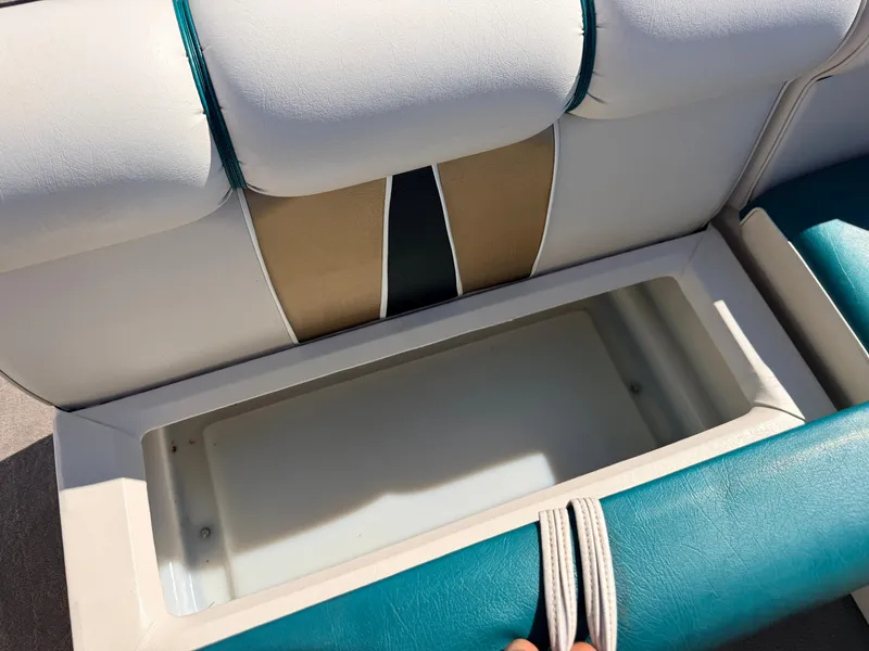 Slide: The Image of An open storage compartment on a boat with cushioned seats in white and blue. - 29