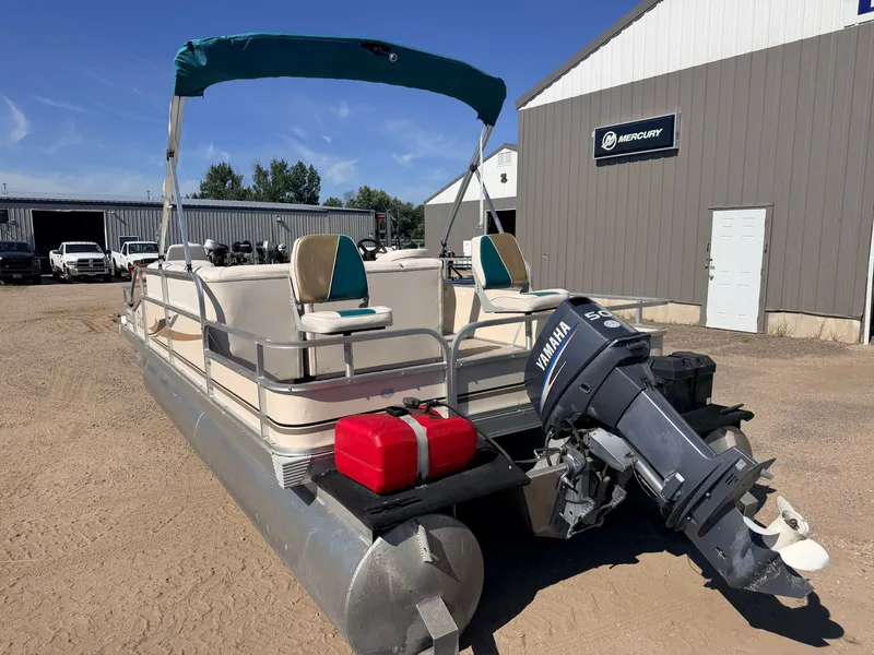 Slide: The Image of A pontoon boat with a 50HP Yamaha engine, featuring a sunshade, is parked on a gravel lot. - 31