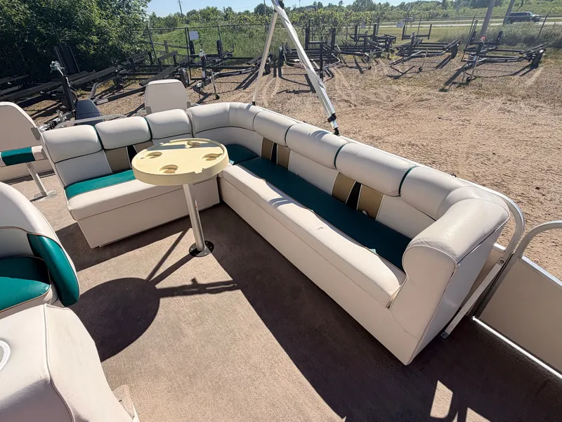 Slide: The Image of A pontoon boat with beige and green seating area and a round table in the center. - 23