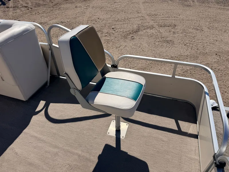 Slide: The Image of A single swivel seat on a boat with blue and white upholstery, surrounded by metal railings. - 11