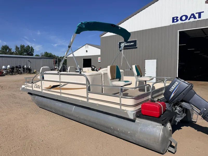 Slide: The Image of A 2006 Elete pontoon boat with a 50HP Yamaha engine, parked on a gravel lot. - 47