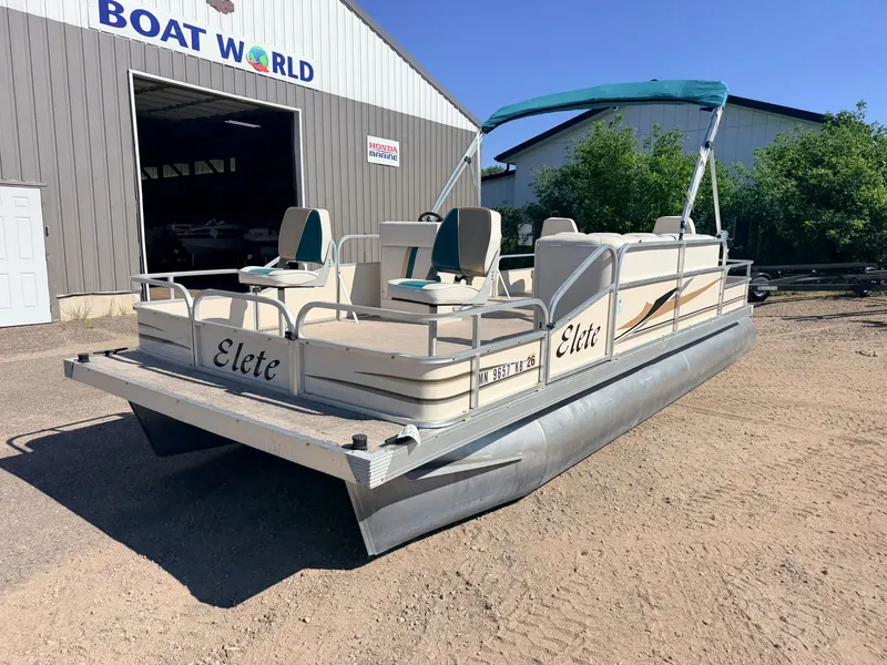 Slide: The Image of A 2006 Elete pontoon boat with a 50HP Yamaha engine, parked on sandy ground. - 39