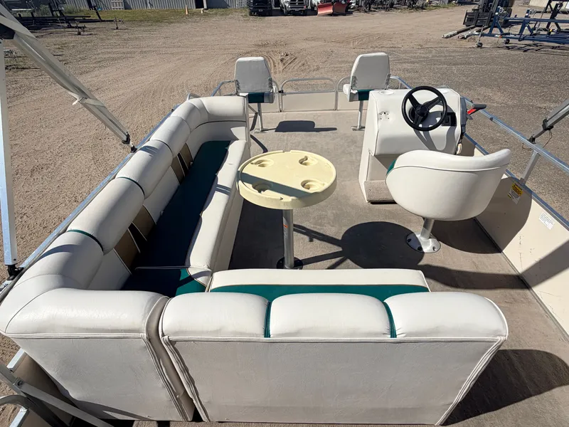 Slide: The Image of A pontoon boat with white upholstery and a small table in the center. - 6