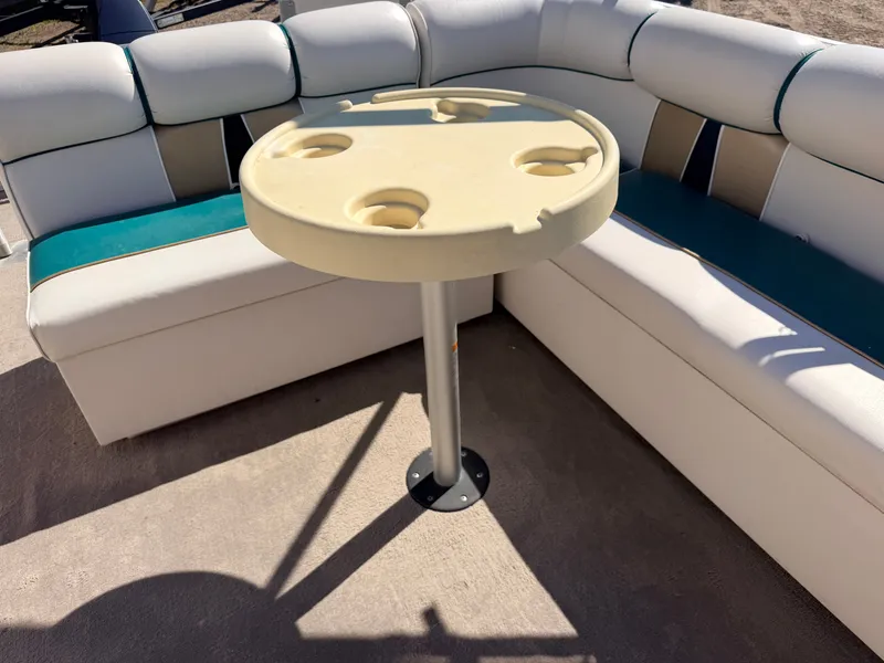 Slide: The Image of A boat with a cozy seating area and a round table featuring cup holders. - 30
