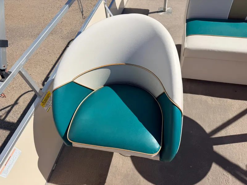 Slide: The Image of A boat seat with white and teal upholstery on a deck. - 20