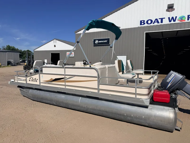 Slide: The Image of A pontoon boat with a 50HP Yamaha engine is parked outside a building. It features a green canopy. - 46