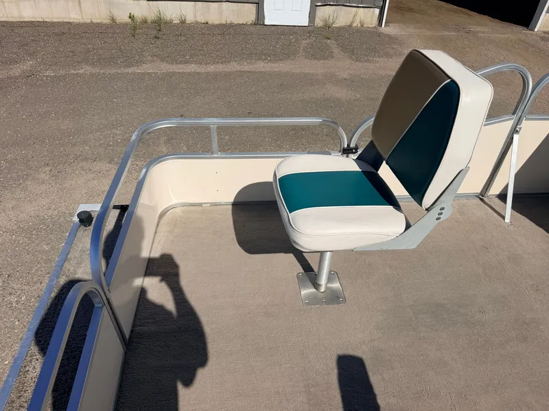 Slide: The Image of A single seat on a pontoon boat with metal railing and carpeted floor. - 14