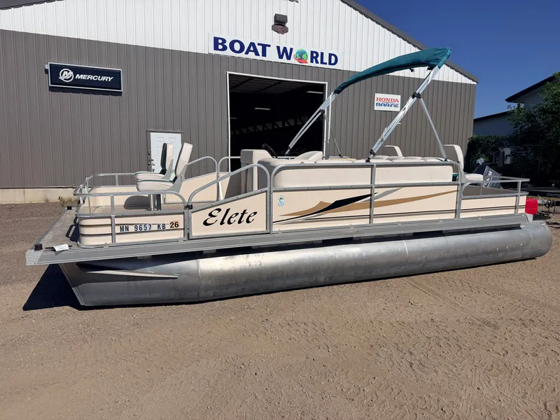 Slide: The Image of A pontoon boat named "Elete" is on dry ground in front of a building labeled "Boat World." It features a canopy and seating. - 42