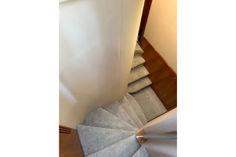 Slide: The Image of Curved carpeted staircase inside 2008 Azimut 55E yacht, featuring wooden paneling. - 19