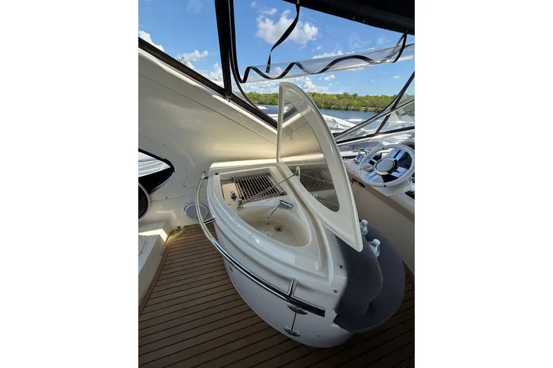 Slide: The Image of 2008 Azimut 55E yacht interior with open hatch and steering wheel, under clear blue sky. - 33
