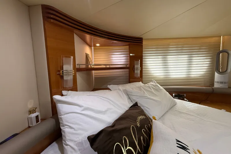 Slide: The Image of Luxurious bedroom interior of 2008 Azimut 55E yacht with elegant wood accents and plush bedding. - 22