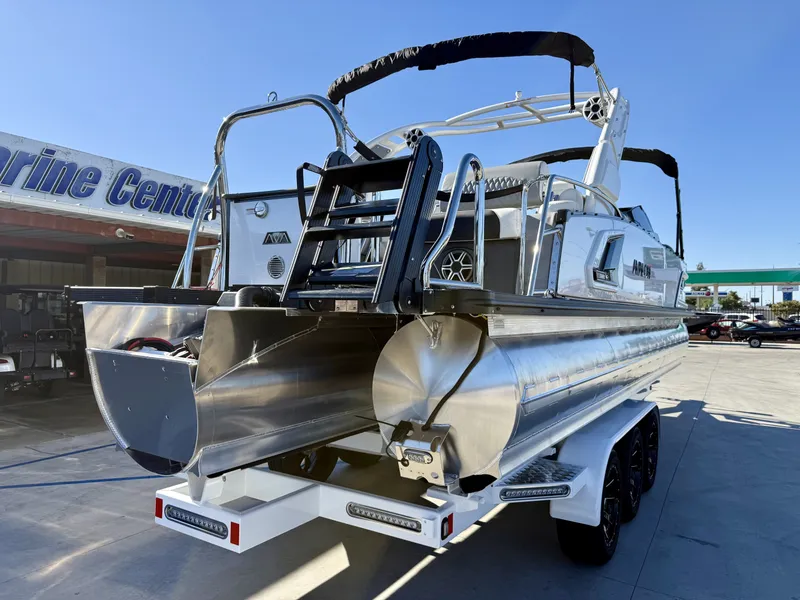 Slide: The Image of The image shows an Avalon Excalibur 27' LTD Quad Lounge boat with a 400HP engine. It's on a trailer at a marine center. - 5