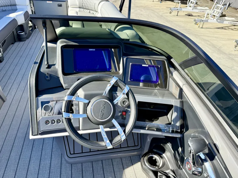 Slide: The Image of The image shows the cockpit of an Avalon Excalibur 27' LTD Quad Lounge with a modern steering wheel and two screens. - 14