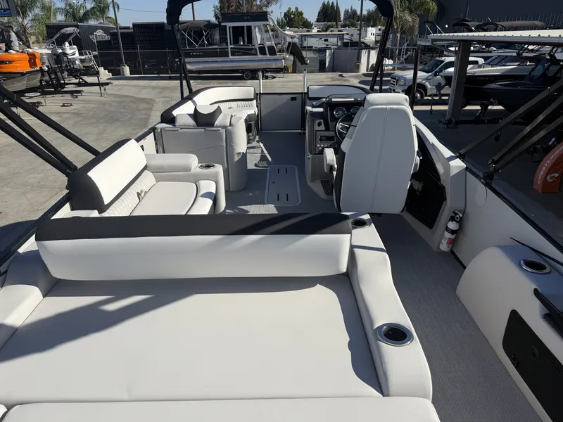 Slide: The Image of The image shows the interior of an Avalon 25' Catalina Platinum boat with luxurious white seating and a helm. - 11