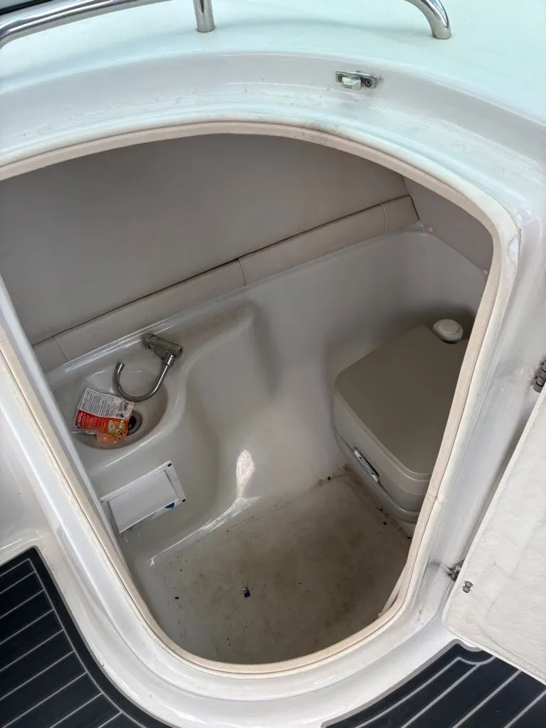 Slide: The Image of The image shows a small boat toilet with a sink and a portable toilet. - 2