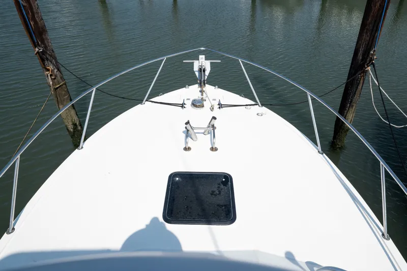 Slide: The Image of Bow view of 2001 Carolina Classic 28 Express boat docked in calm waters. - 15