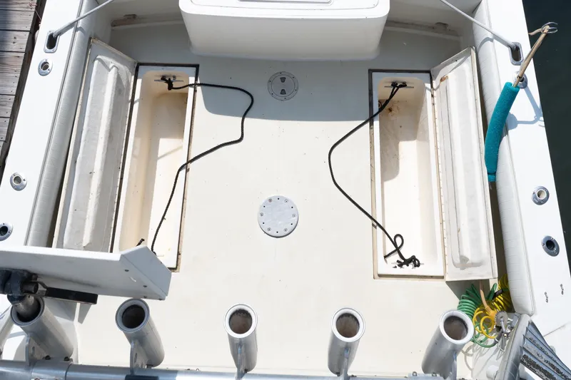 Slide: The Image of 2001 Carolina Classic 28 Express boat deck with storage compartments and fishing rod holders. - 14