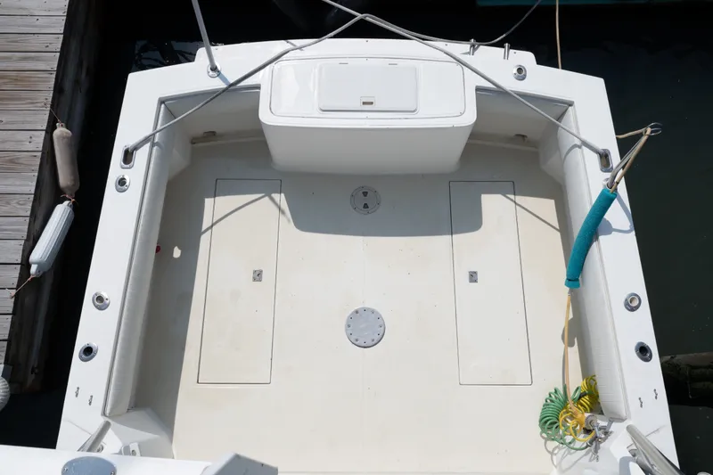 Slide: The Image of 2001 Carolina Classic 28 Express boat deck, featuring spacious layout and storage compartments. - 13