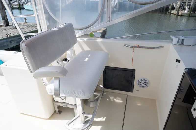 Slide: The Image of 2001 Carolina Classic 28 Express boat interior with cushioned seating and waterfront view. - 6