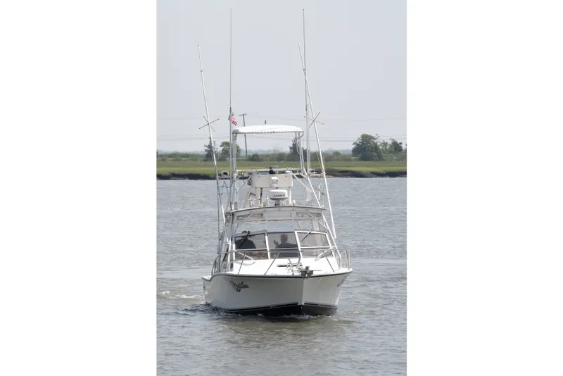Slide: The Image of 2001 Carolina Classic 28 Express boat cruising on a calm river. - 2