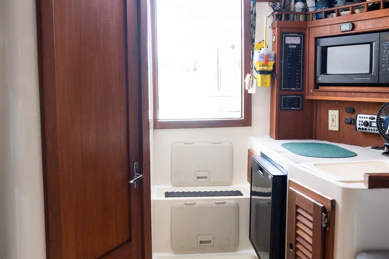 Slide: The Image of Interior of 2001 Carolina Classic 28 Express boat with kitchenette and wooden cabinetry. - 9