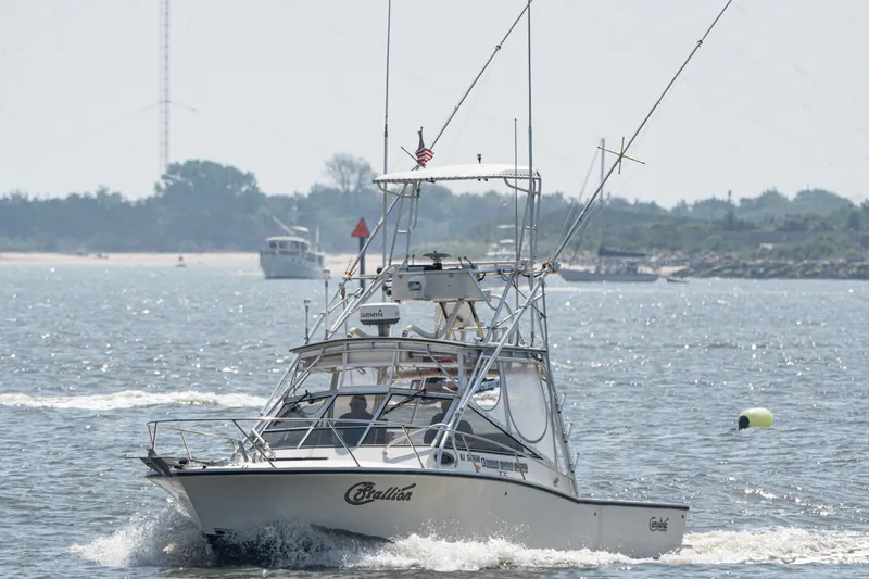 The Image of 2001 Carolina Classic 28 Express boat cruising on a sunny day near the shore. - 1