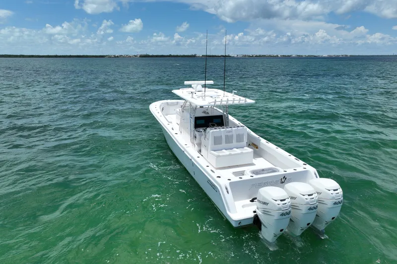 Slide: The Image of 2013 Invincible 42 Open Fisherman boat with triple Mercury engines on turquoise water. - 1