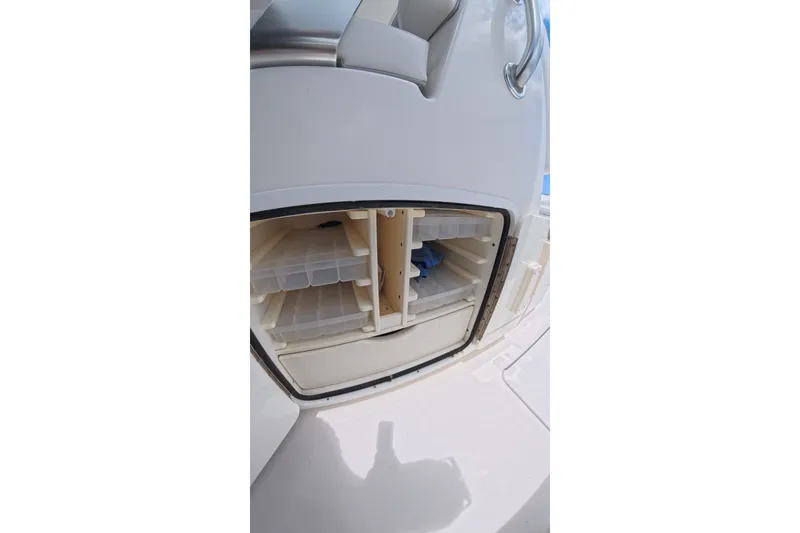 Slide: The Image of Storage compartment on a 2013 Invincible 42 Open Fisherman boat, featuring organized shelves. - 31