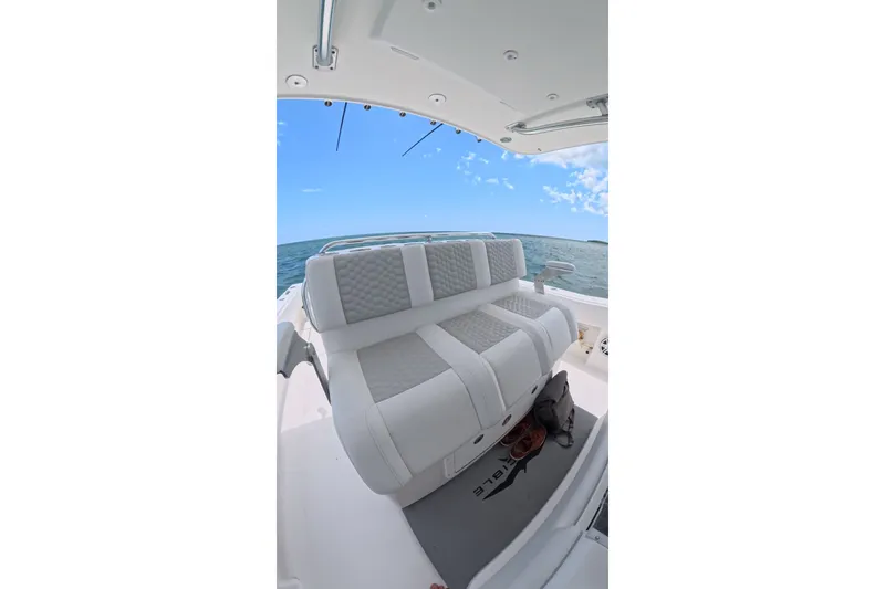 Slide: The Image of 2013 Invincible 42 Open Fisherman boat interior with cushioned seating and ocean view. - 19