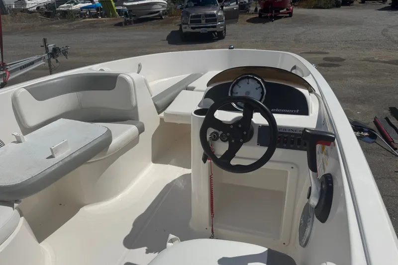 Slide: The Image of 2014 Bayliner 160 Element boat interior with steering wheel and seating area. - 6