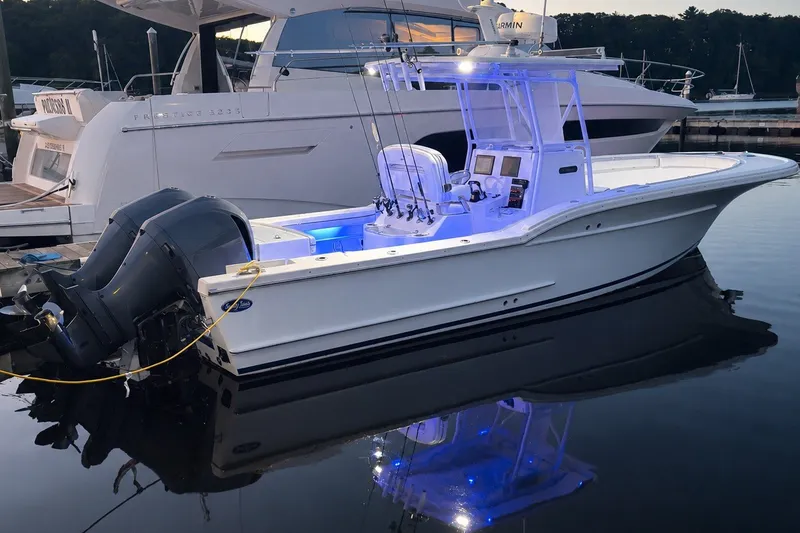 Slide: The Image of A white 2014 Buddy Davis 28 Center Console boat is docked, illuminated by blue lights. - 27