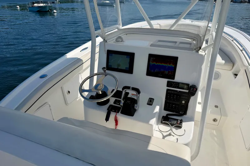 Slide: The Image of The cockpit of a 2014 Buddy Davis 28 Center Console boat with steering and electronics. - 14