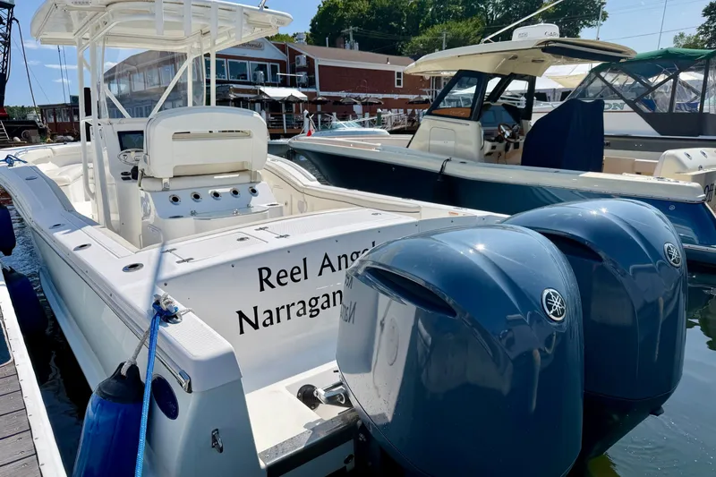 Slide: The Image of A 2014 Buddy Davis 28 Center Console boat is docked. It features dual outboard engines. - 24