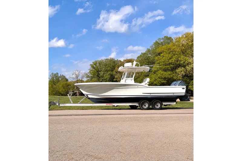 Slide: The Image of A white 2014 Buddy Davis 28 Center Console boat on a trailer, parked on a road. - 29