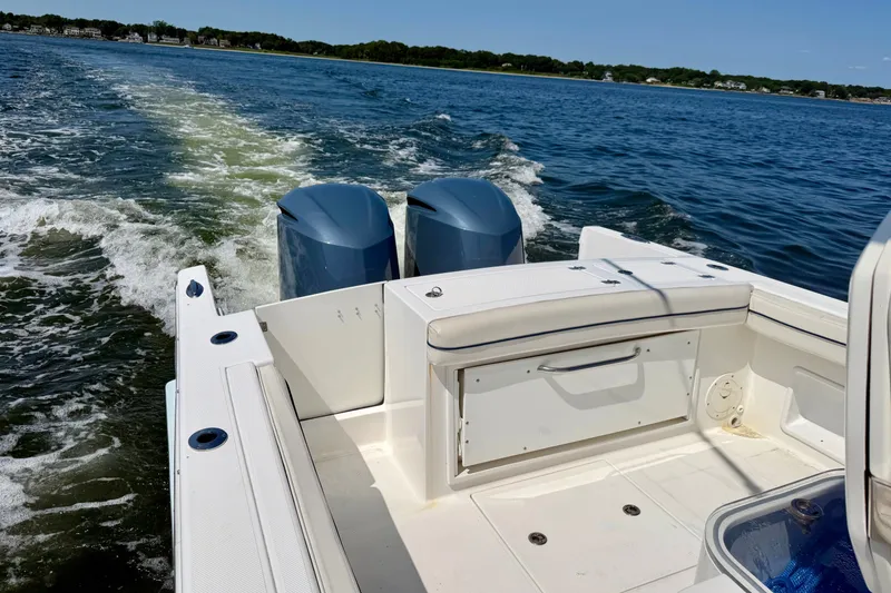 Slide: The Image of The image shows the stern of a 2014 Buddy Davis 28 Center Console boat on the water. - 11