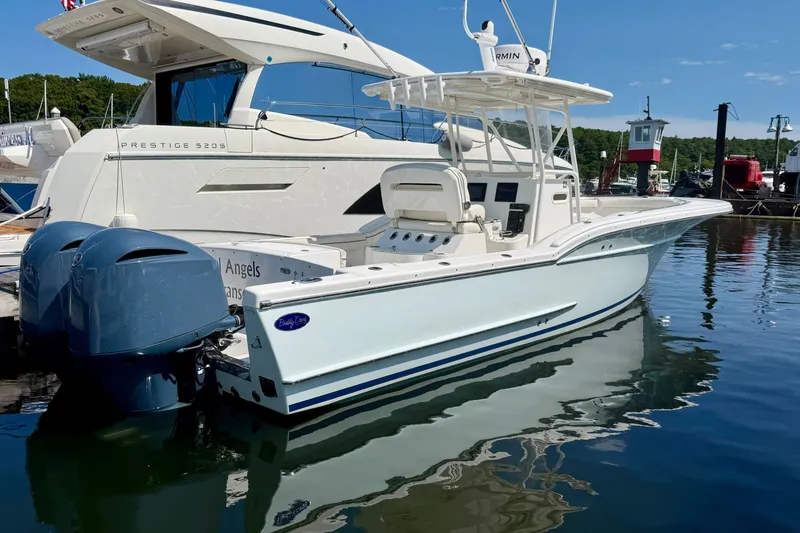 Slide: The Image of A white 2014 Buddy Davis 28 Center Console boat is docked beside a yacht. - 22