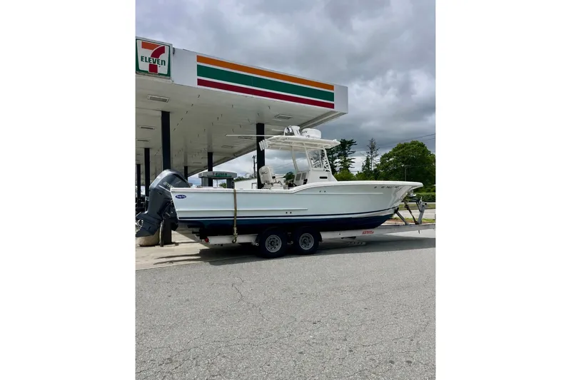 Slide: The Image of A 2014 Buddy Davis 28 Center Console boat on a trailer at a gas station. - 30