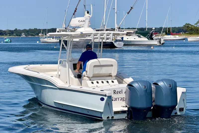 Slide: The Image of A 2014 Buddy Davis 28 Center Console boat on calm water, featuring twin outboard engines. - 4