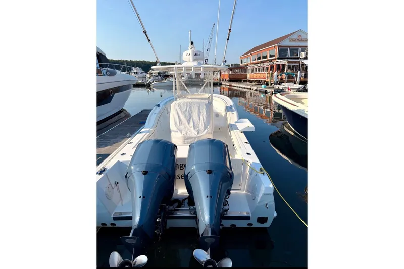 Slide: The Image of A 2014 Buddy Davis 28 Center Console boat docked in a marina. It features twin outboard engines. - 28