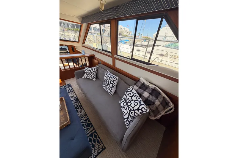 Slide: The Image of Luxurious interior of 1990 Californian 48 Motor Yacht with elegant sofa and decorative pillows. - 58