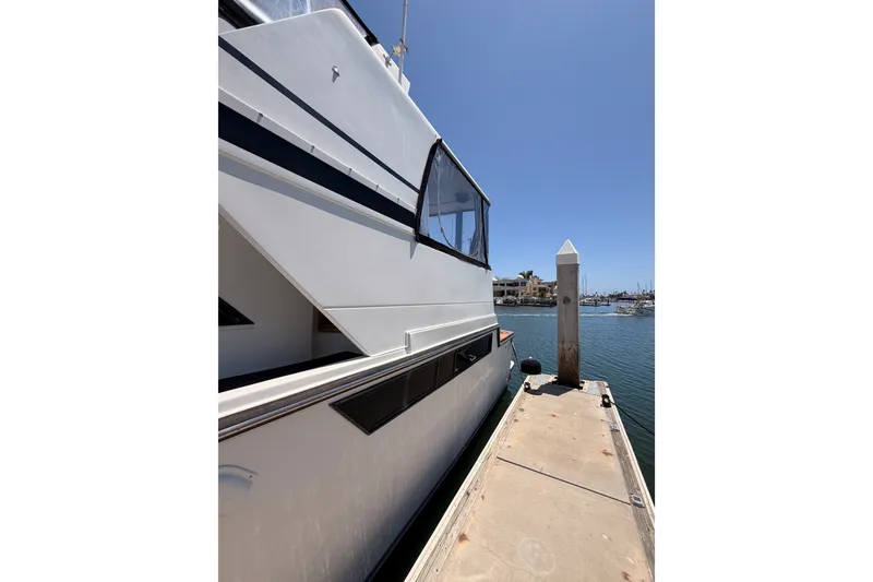 Slide: The Image of 1990 Californian 48 Motor Yacht docked at marina under clear blue sky. - 6