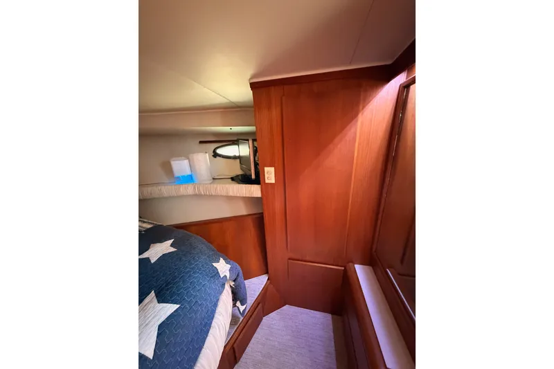 Slide: The Image of Interior cabin of 1990 Californian 48 Motor Yacht with wooden paneling and star-patterned bedding. - 72