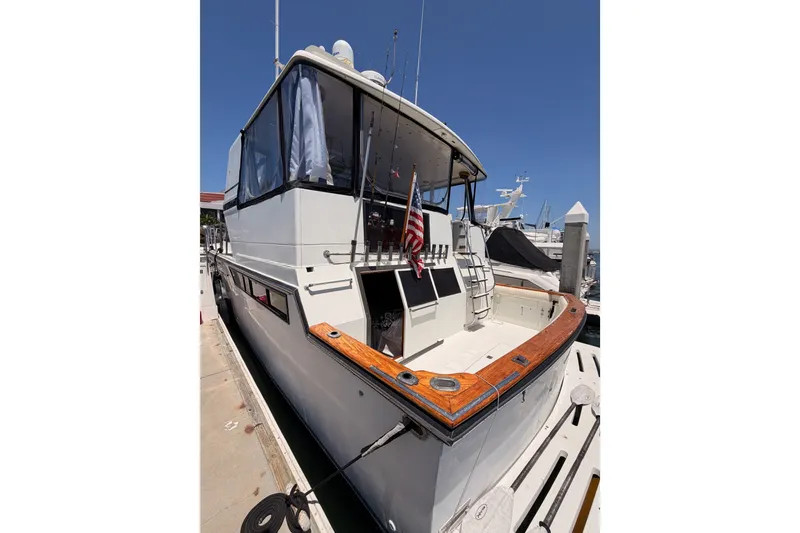 Slide: The Image of 1990 Californian 48 Motor Yacht docked at marina, featuring sleek design and American flag. - 8