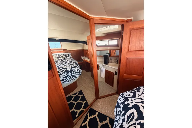 Slide: The Image of Interior of 1990 Californian 48 Motor Yacht with wood paneling and patterned bedding. - 100