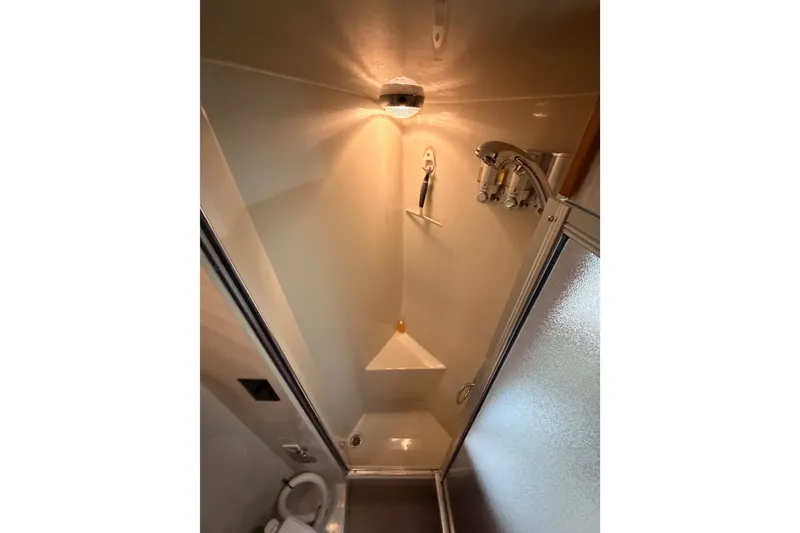 Slide: The Image of Shower area in 1990 Californian 48 Motor Yacht, featuring modern fixtures and lighting. - 77