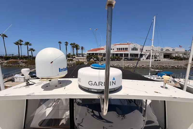 Slide: The Image of 1990 Californian 48 Motor Yacht with Garmin and Intellian equipment, docked near palm trees and buildings. - 33